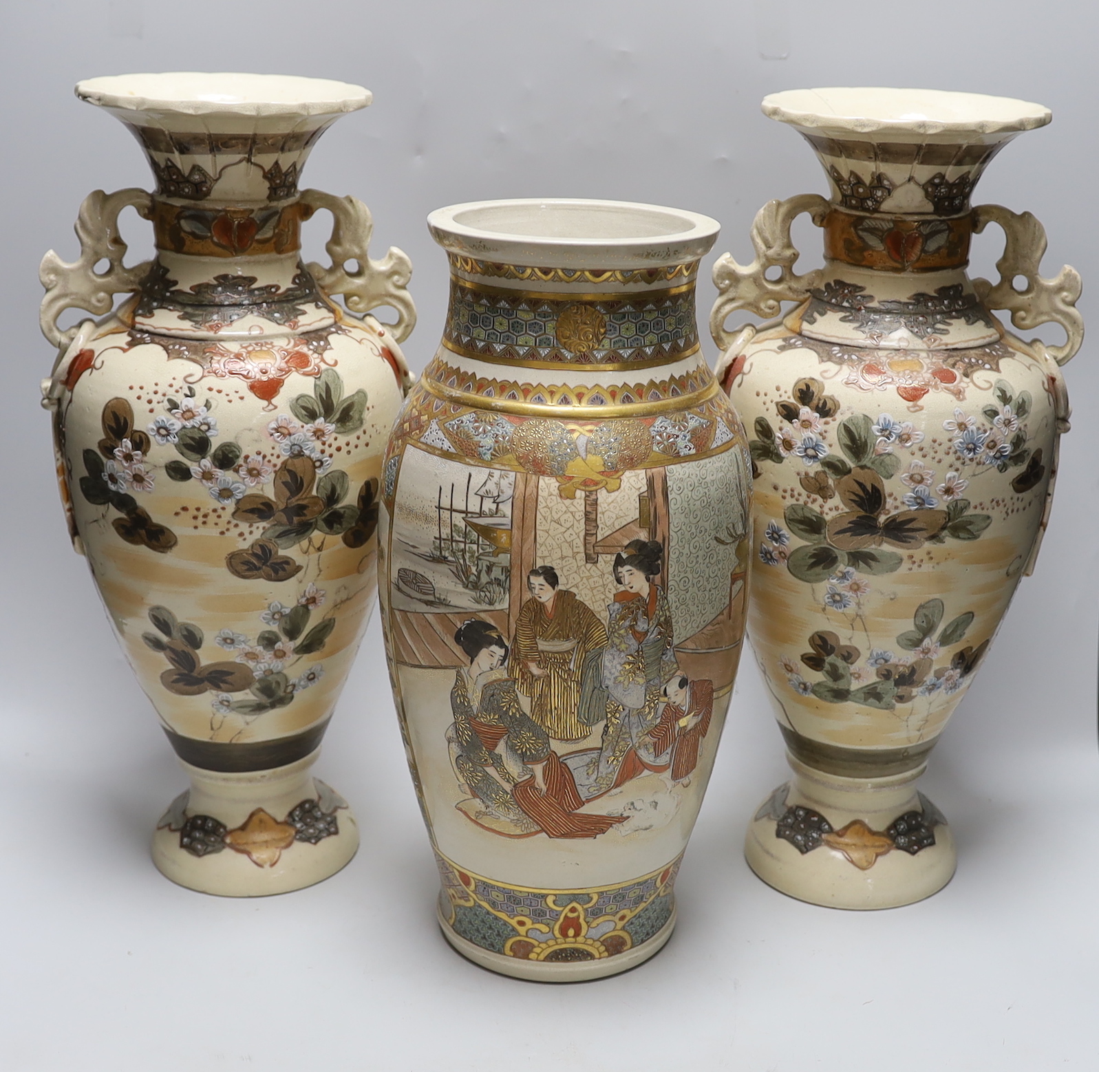 A pair of late 19th century Japanese Satsuma vases and a similar example, the largest each 42cm high (3)